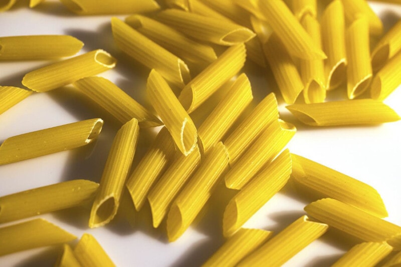 Close-up view of uncooked penne pasta.
