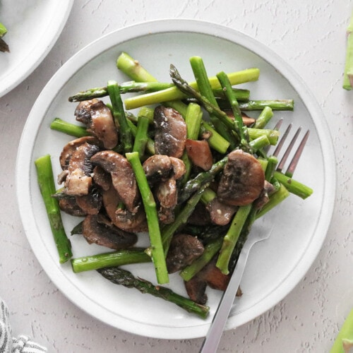 Roasted asparagus and mushrooms on a white plate