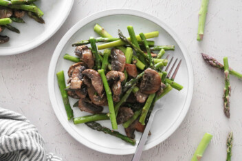 Roasted asparagus and mushrooms on a white plate
