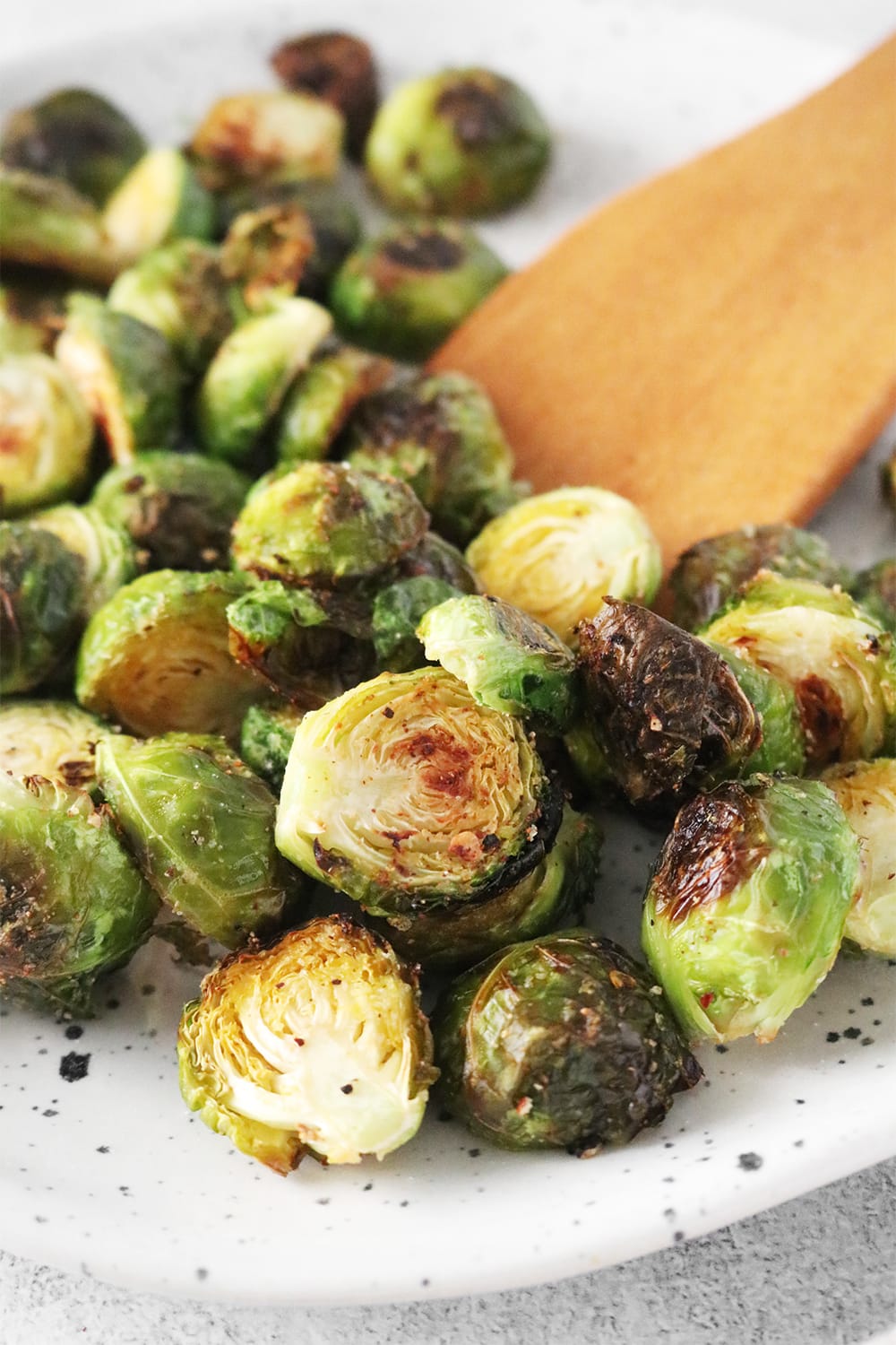 Roasted Brussels sprouts on a speckled white plate