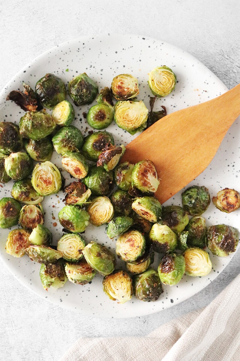 Roasted Brussels sprouts on a speckled white plate