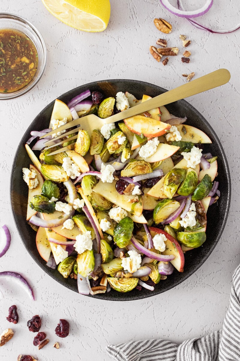 Roasted Brussels sprouts salad on a black plate.