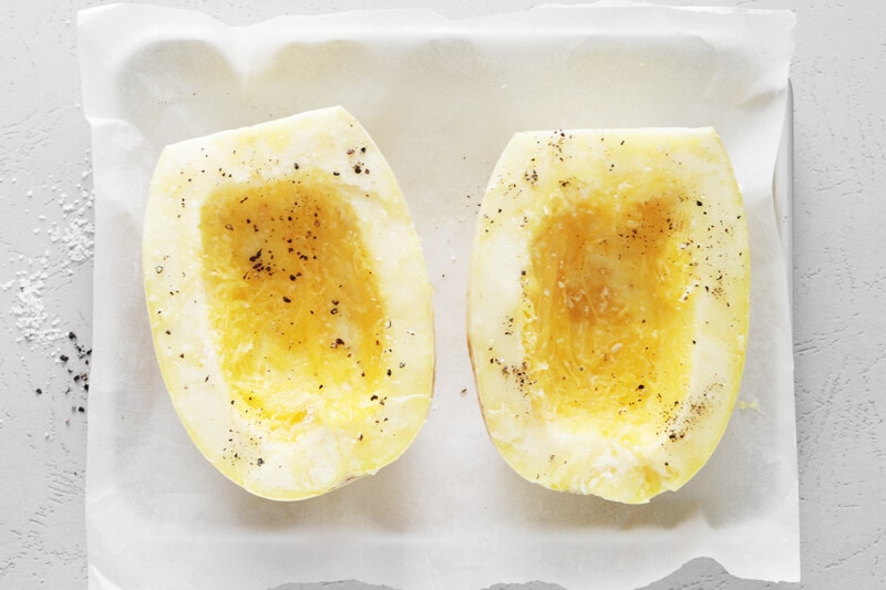 Coat spaghetti squash halves with olive oil and spices and place on a baking sheet, cut side facing up.