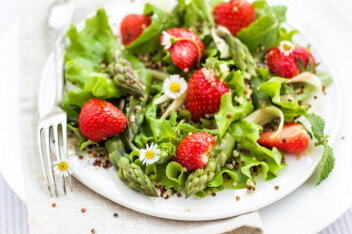 Fresh spring salad topped with strawberry and asparagus.