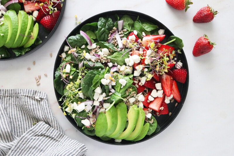 Strawberry Spinach Salad in a black bowl.