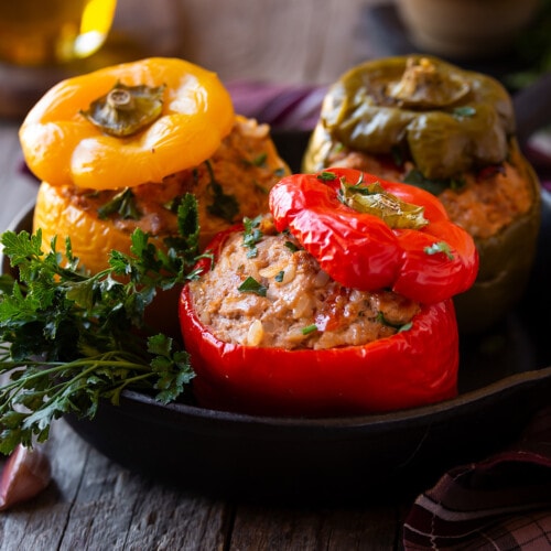 Stuffed bell peppers in a cast iron pan on a wooden table