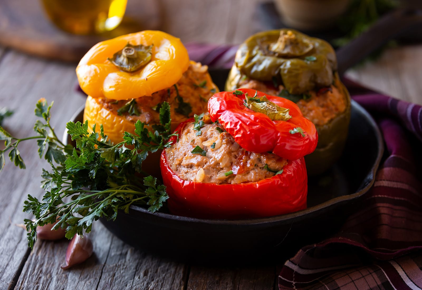 Stuffed bell peppers in a cast iron pan on a wooden table