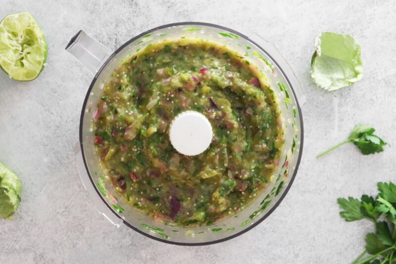 Tomatillo green chili salsa in a food processor.