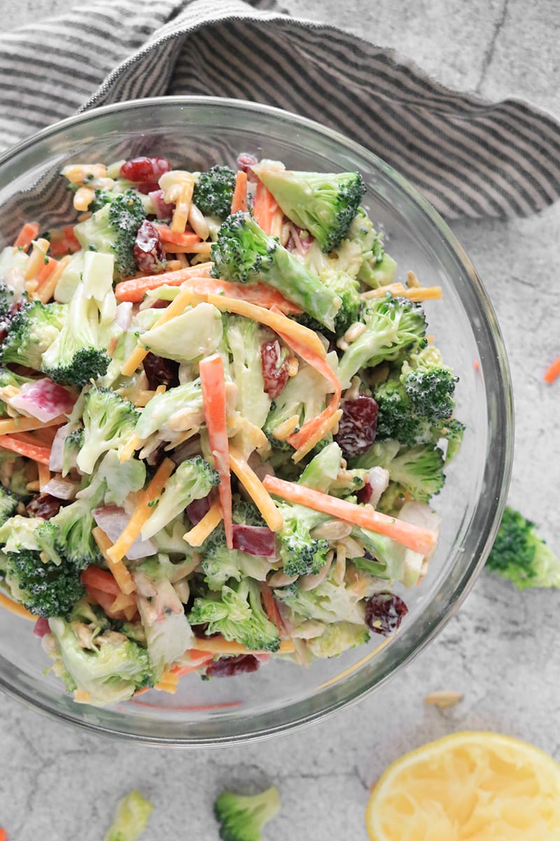 Vegan broccoli salad with carrots and dried cranberries in a bowl.