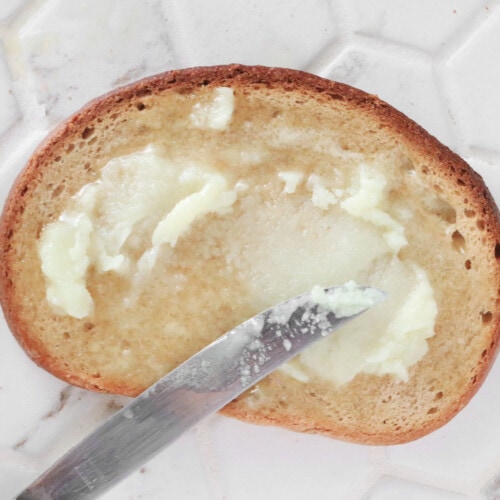 Vegan butter being spread on a slice of bread
