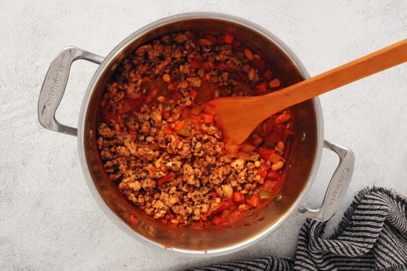 Adding tempeh meat crumbles to pot of chili