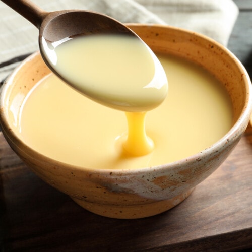 Vegan/Dairy-free sweetened condensed milk substitute pouring off of a spoon into a bowl