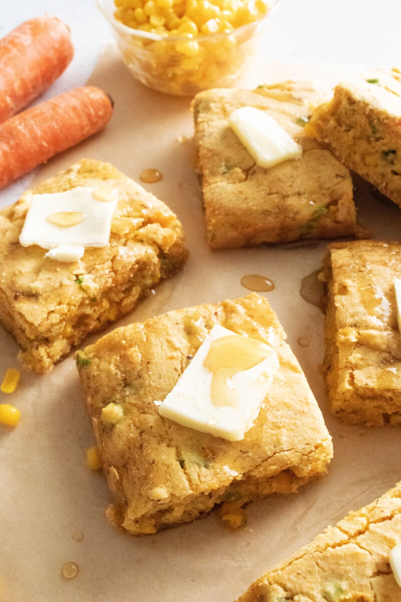 Vegan cornbread with carrots and scallions on parchment paper.