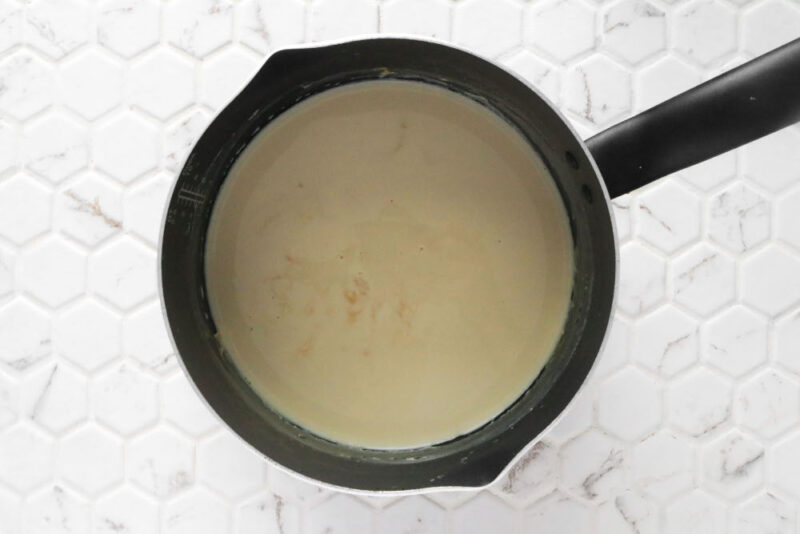 Simmering down plant-based milk in a small pot to make evaporated milk