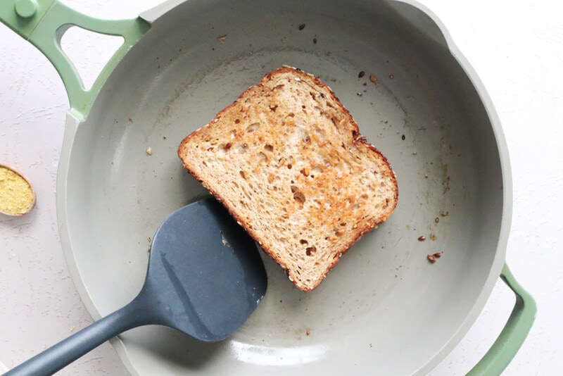Vegan grilled cheese cooking in a skillet.