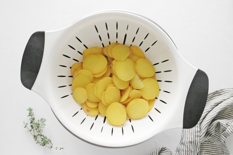 Draining scalloped potatoes in a colander