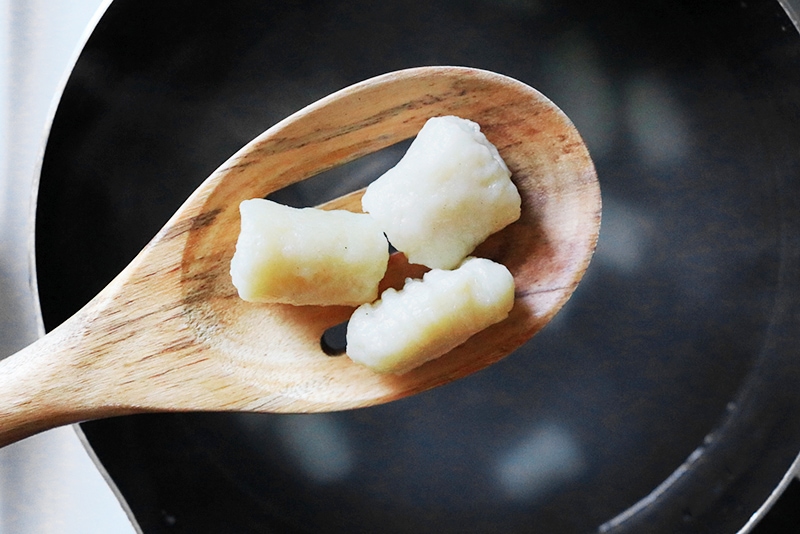 Potato Gnocchi in a slotted wooden spoon