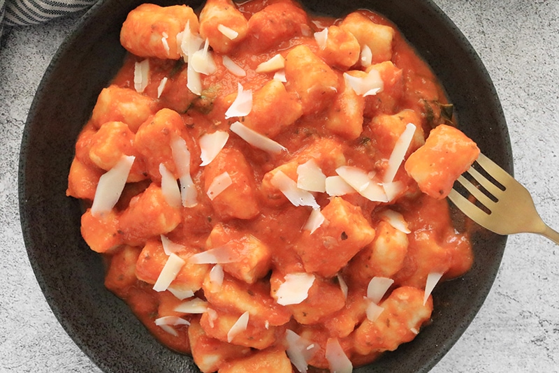 Vegan Potato Gnocchi served in a bowl with vegan parmesan cheese