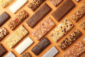 A variety of vegan protein bars arranged on a plain background.