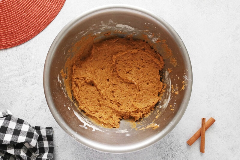 Wet ingredients and dry ingredients combined into a batter for vegan pumpkin cream cheese muffins.