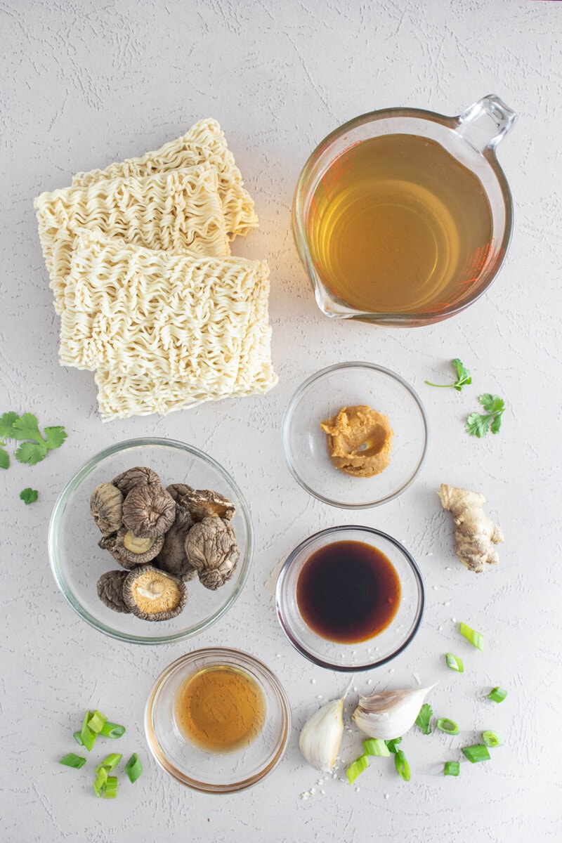 Vegan ramen ingredients: vegetable broth, miso, soy sauce, dried shiitake mushrooms, garlic, ginger, and sesame oil.