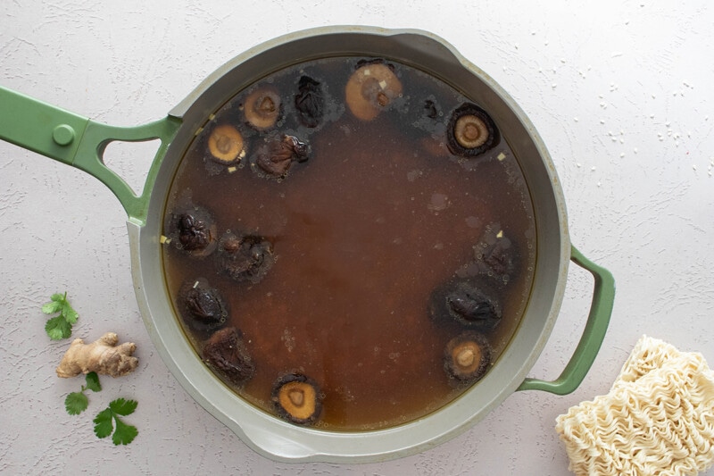 Broth, mushrooms, and liquid ingredients simmering in the skillet.