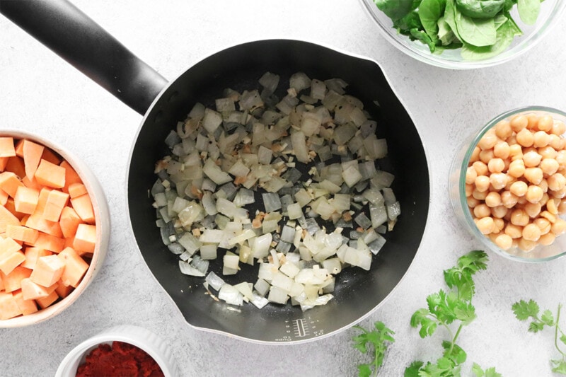 sautéing onions, garlic, and ginger in a pot