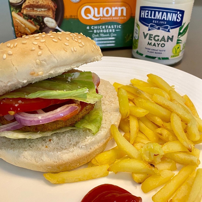 A vegan Chicktastic Burger on a plate with fries and ketchup.